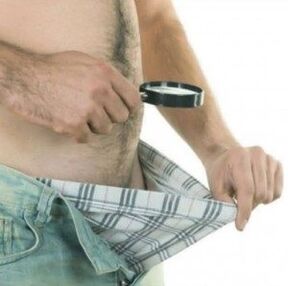 a man looks under his pants and wants to enlarge his penis with gel